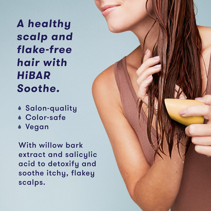 Woman washing hair with conditioner bar. HiBAR Soothe conditioner bar gives you a healthy scalp and flake-free hair, is salon-quality, color-safe, vegan, and contains willow bark extract and salicylic acid to detoxify and soothe itchy, flakey scalps.