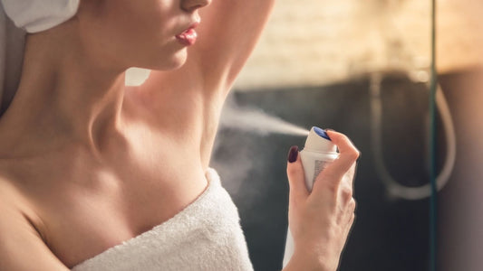 Woman spraying her underarm with an antiperspirant