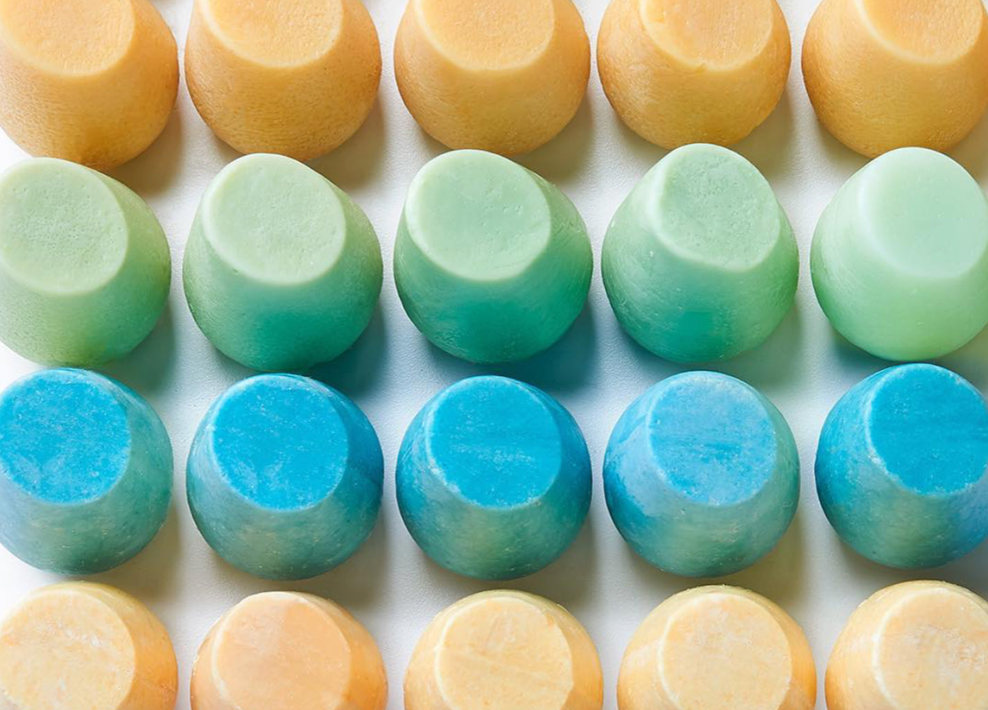 a collection shampoo bars next to each other showing the bright colors of bars