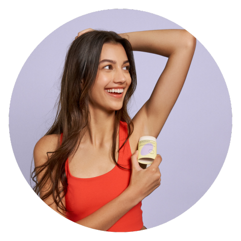 Woman holding deodorant bar to her armpit.