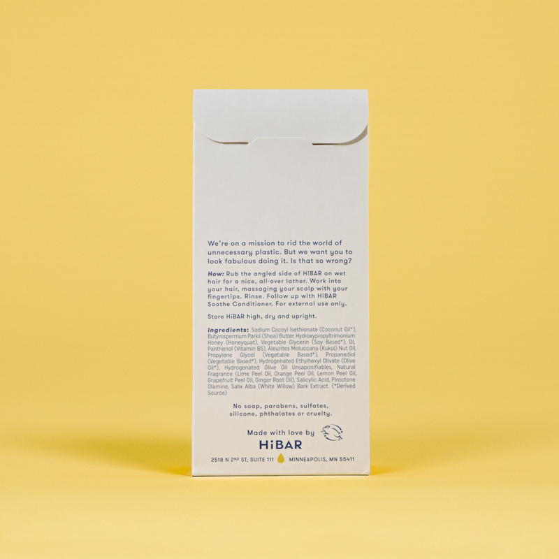 Photo of the back of the packaging of the shampoo bar on a yellow background.