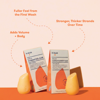 HIBAR solid shampoo bars  and conditioner bars with packaging on a peach background with product highlights: Fuller feel from the first wash. More Volume + Body. Stronger, thicker strands over time. 